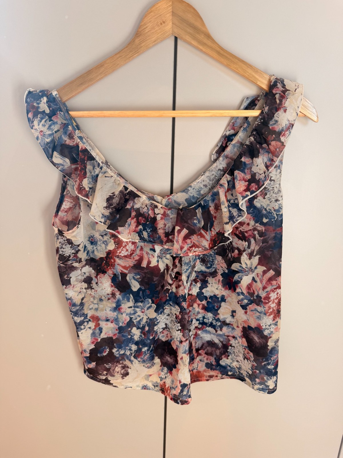 Top floral sin mangas con escote de volante