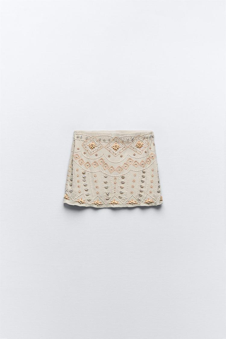Falda beige corta bordada con conchas